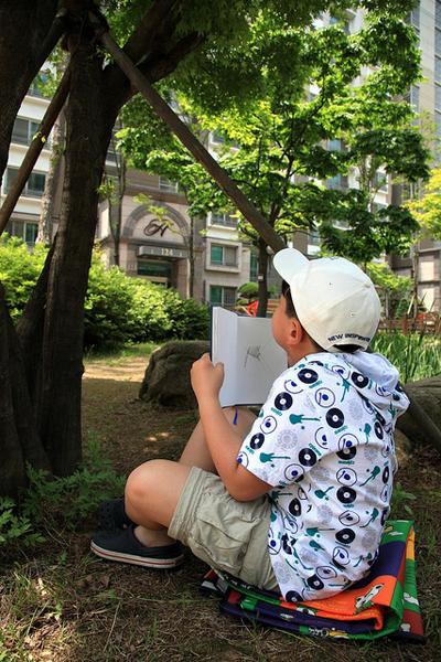 어린 아이가 풀밭에 앉아 있는 사진