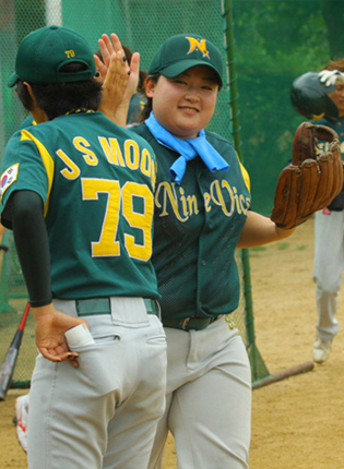 하이파이브를 하는 여자 야구선수들의 모습