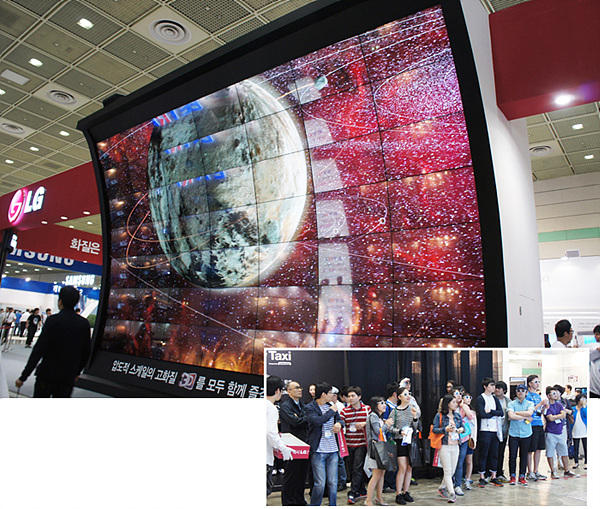 대형 스크린에 펼쳐진 LG 시네마 3D 영상의 모습이다. 수많은 관람객들이 스크린 앞에 서서 화면을 응시하고 있다. 