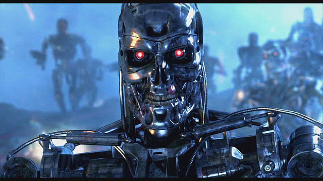 영화 터미네이터의 한 장면으로 해골 얼굴 모양의 은색 로봇이 빨간색 눈을 번뜩이며 쳐다보고있다