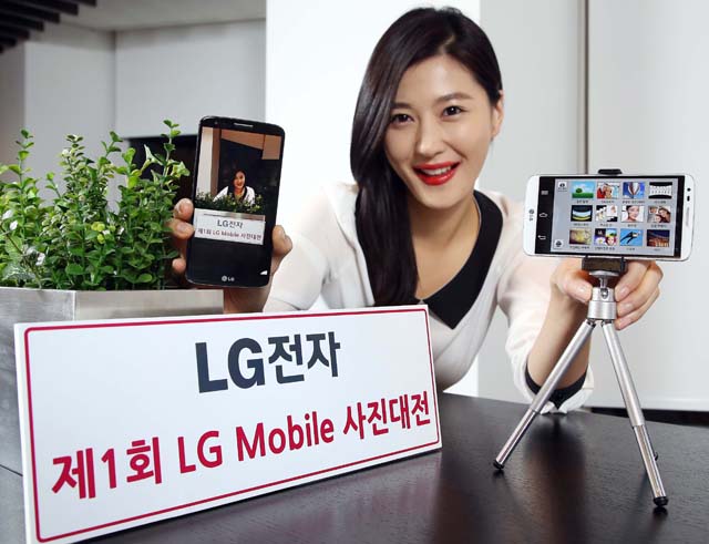 모델이 LG G2를 들고 포즈를 취하고 있다.