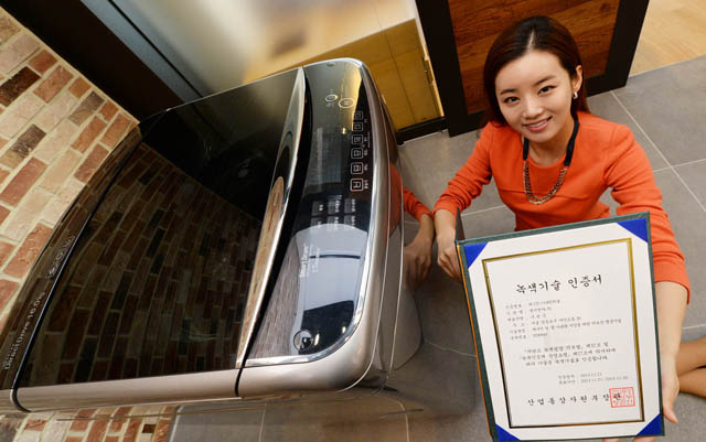 서울 여의도 소재 LG트윈타워에서 여성 모델이 LG 세탁기의 '터보샷' 기술로 받은 '녹색기술' 인증서를 소개하고 있다. 제품은 이 기술을 적용한 LG '블랙라벨' 세탁기다.