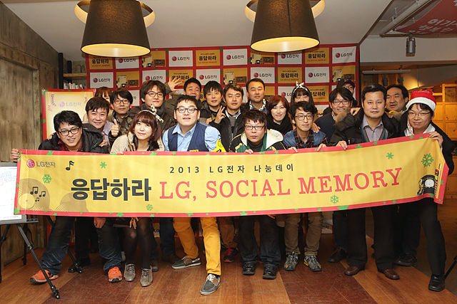 2013 LG전자 나눔데이에 참석한 더블로거들의 단체 사진. 앞줄의 사람들이 응답하라 LG, 소셜 메모리 현수막을 들고 있다.