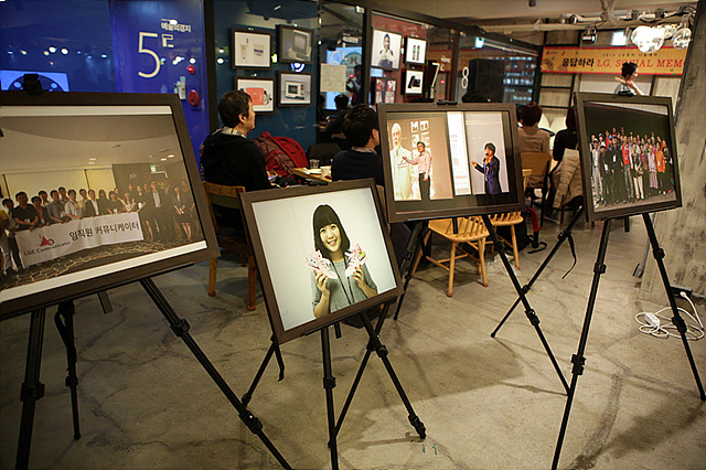 소셜LG 나눔데이 행사장 내부의 모습으로, 4개의 이젤 위에 크게 인쇄된 2013년 LG전자 행사 사진이 액자에 끼워져 놓여 있다.