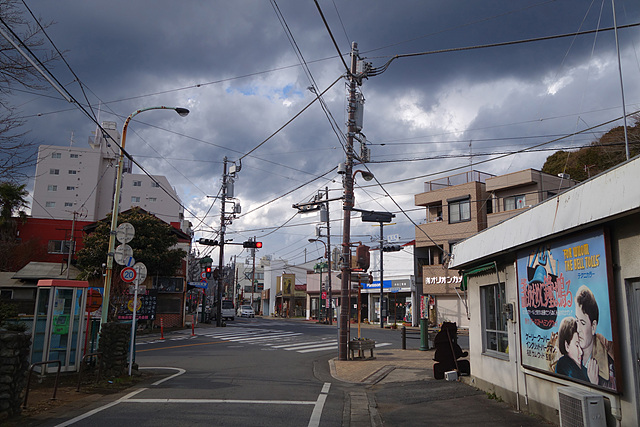 오우메 역근처의 모습으로 하늘 위엔 구름이 가득 떠있고 우측에는 손간판도 보인다.