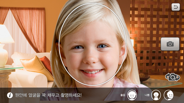 여자 아이가 자신의 얼굴사진을 찍어 애니메이션 동화에 넣을 아바타를 만들고 있다.