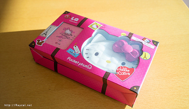 포켓포토의 헬로키티 에디션이다. 상자에 키티 모양의 포켓포토 가방과 키티가 그려진 분홍색 포켓포토가 들어간 상자가 놓여있다.