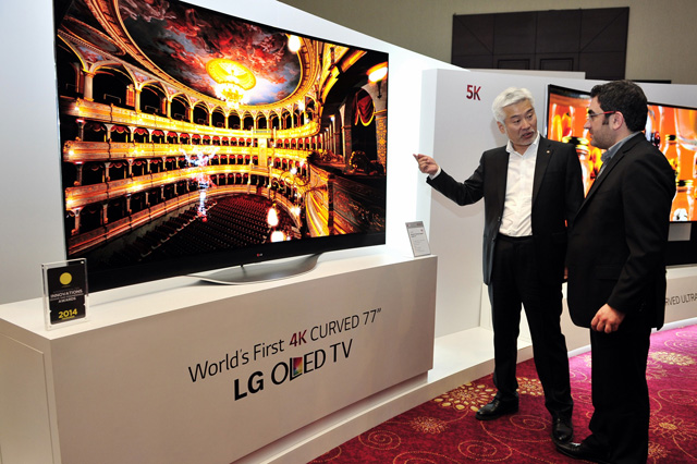 LG전자 중아지역대표 차국환 전무(왼쪽)가 주요 거래선에게 77형 울트라HD 곡면 올레드 TV를 소개하고 있다. 