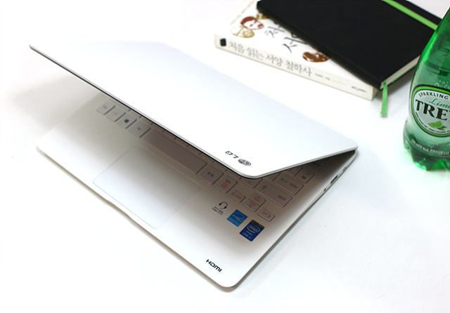 흰 책상위에 반 만 오픈되어 있는 노트북 그램의 모습이다.