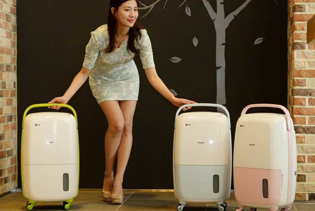 여성 모델이 여행가방처럼 이동 편의성과 디자인을 강화한 LG 휘센 제습기 신제품을 소개하고 있습니다.