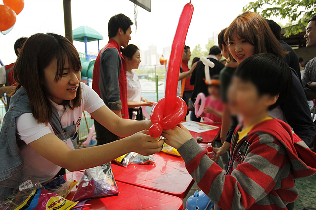 러브지니 윤재경 학생이 아이에게 빨간풍선으로 만든 칼자루를 쥐어주고있는 모습이다
