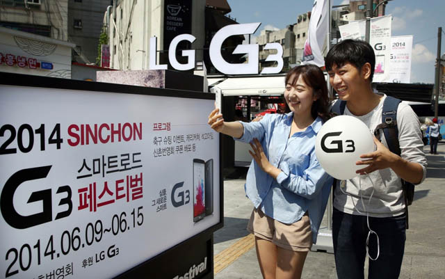 신촌 연세로 내에 설치된 'LG G3' 체험존 앞에서 일반인 커플들이 'G3'로 사진 촬영을 하면서 즐거워 하고 있는 모습 입니다.