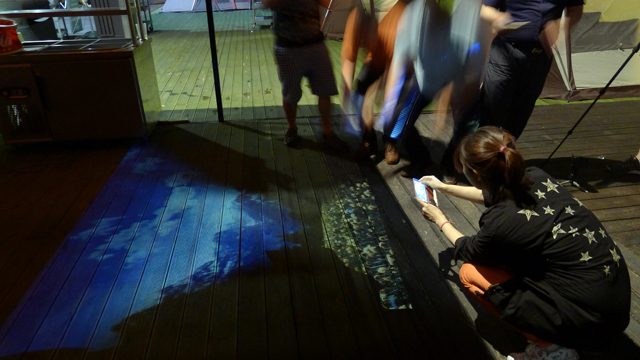 더블로거들이 미니빔 TV로 바닥에 쏘아진 이미지를 활용해서 영상을 만들고 있는 모습이다