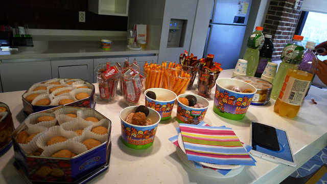 테이블 위에 쿠키, 소시지, 음료 등 다과가 준비되어 있다