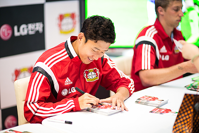 손흥민 선수가 미소를 지으며 싸인을 해주고 있다.
