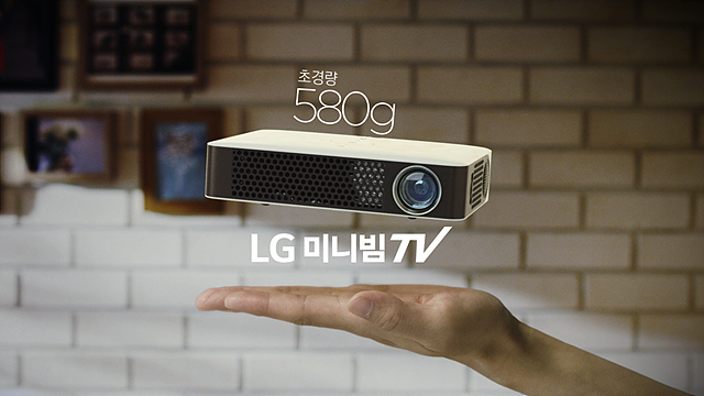 가벼운 미니빔 TV를 보여주는 광고 이미지. 손바닥 위에 떠 있는 580G 초경량 LG 미니빔 TV