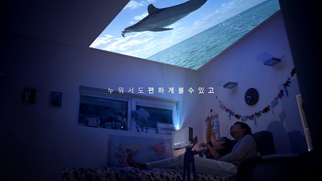 미니빔 TV를 통해 누워서 천장에 비친 고래를 보고있다.