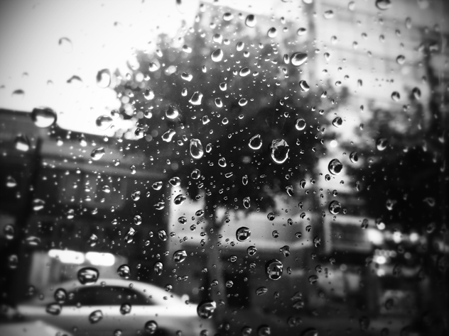 빗방울이 맺혀 있는 유리창. 흑백사진.