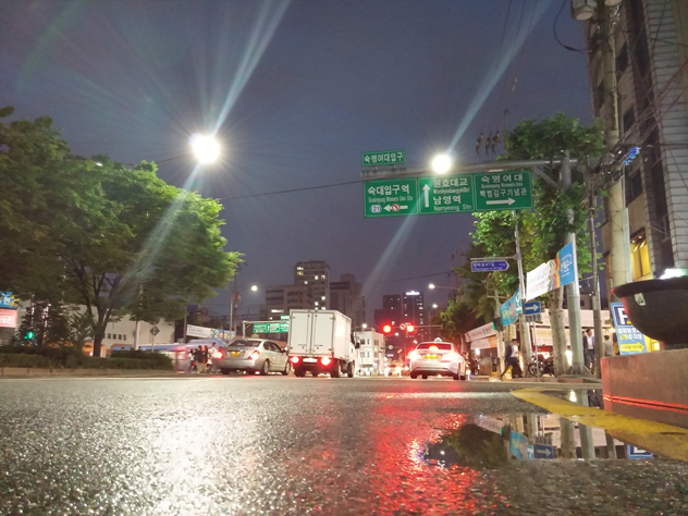 비온 뒤 갠 서울의 거리. 아스팔트 위 빗물이 고여있다.