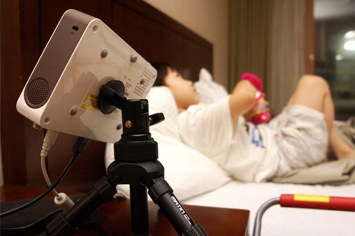 침대에 누워있는 아이를 배경으로 LG 미니빔TV가 보인다.