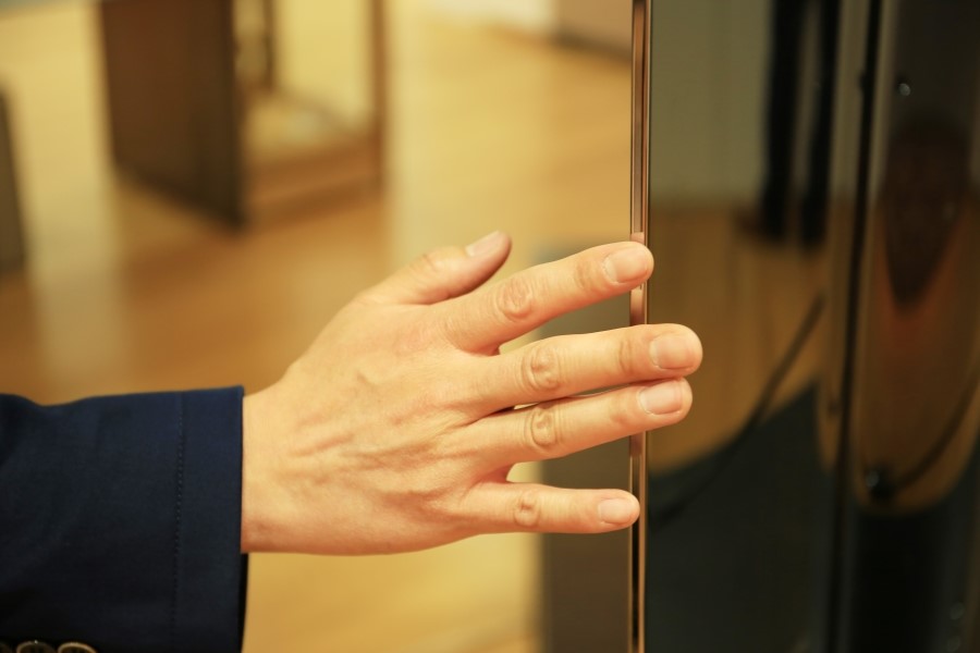 LG전자 울트라 올레드 TV의 두께감을 확인하기 위해 손을 대고 있다.