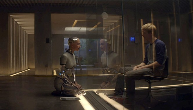 영화 ‘엑스 마키나’ 의 한 장면, 주인공 로봇이 인간과 마주 앉아 있다.