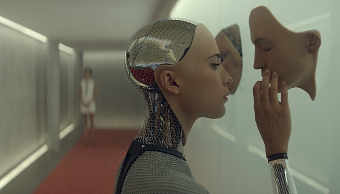 영화 ‘엑스 마키나’ 의 한 장면, 주인공 로봇이 슬픈 표정으로 눈 앞의 로봇 부품을 만지고 있다. 