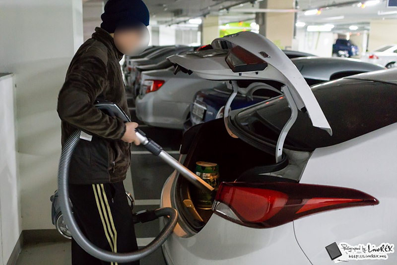  무선 싸이킹으로 차량 트렁크를 청소하고 있다.