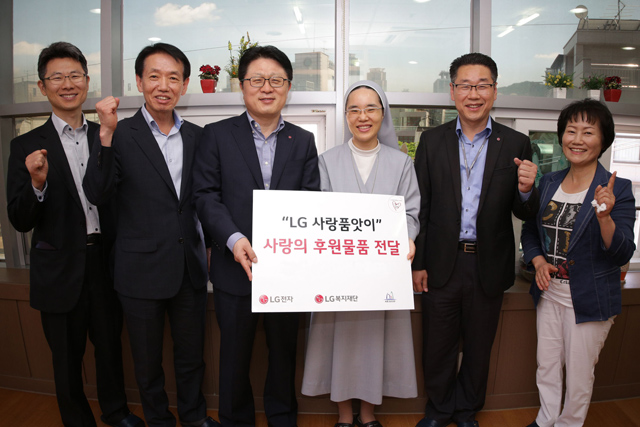 '성심노인센터'에 기념 촬영을 하고 있는 안승권 사장과 김소희 수녀. LG전자 임직원 모습 입니다.