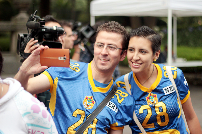 파란색 유니폼을 맞춰 입은 두 사람이 함께 셀피를 촬영하고 있다. 