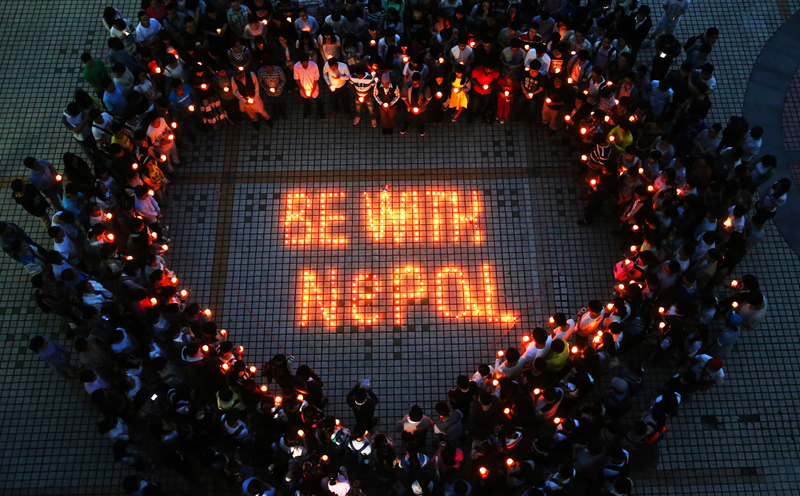 촛불로 하트를 만든 사람들. BE WITH NEPAL 이라는 문구가 가운데 촛불로 밝혀져 있다. 