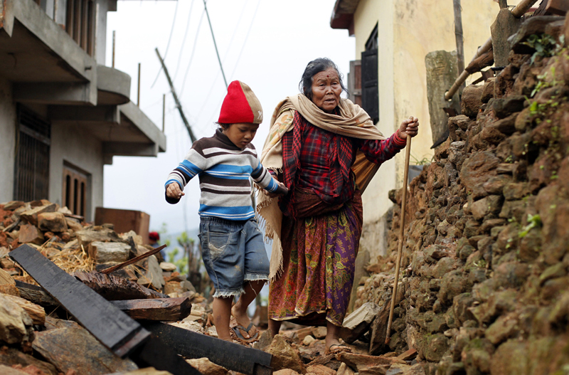 무너진 건물 위를 걷고 있는 노인과 어린아이 