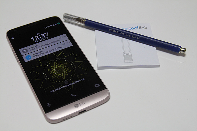 LG G5가 펜, 포스트잇과 함께 흰 탁자 위에 놓여 있습니다.