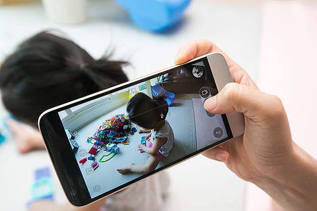 스마트폰으로 아이가 놀고 있는 모습을 촬영하는 사진 