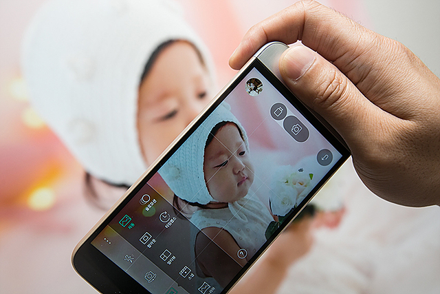 스마트폰으로 딸 아이 사진을 촬영하고 있는 모습