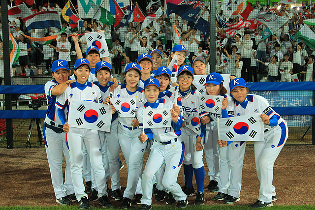 한국 여자야구 대표팀 선수들이 태극기를 들고 서 있는 모습 