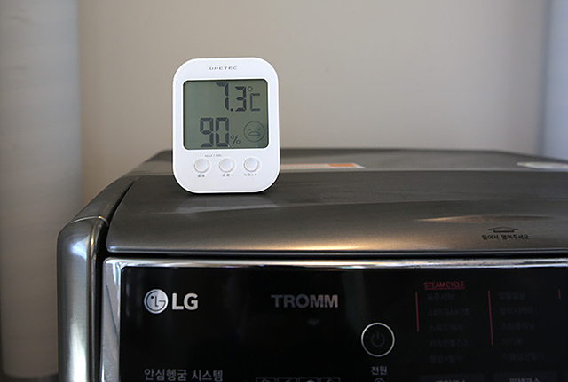 세탁실 온도 측정을 위해 온도계를 사용하고 있는 모습