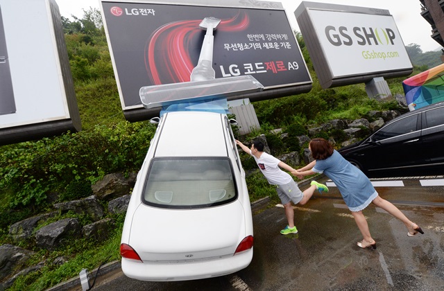: 25일 경기도 광주 소재 곤지암리조트를 찾은 고객들이 LG 코드제로 A9을 홍보하기 위해 주차장에 설치된 이색 옥외광고를 바라보고 있다.
