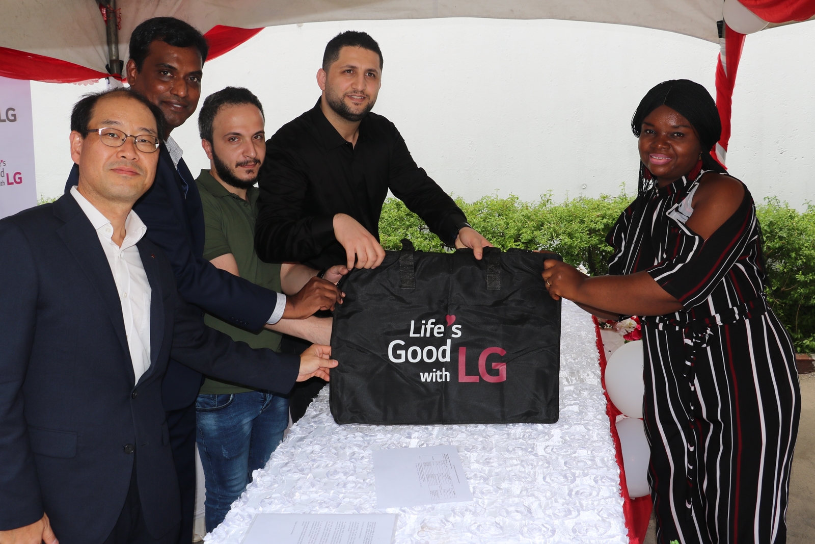 LG전자가 최근 나이지리아 음보음바 마을에 무료 세탁방인 ‘라이프스 굿 위드 LG 워시(Life’s Good with LG Wash)’를 열었다. 무료 세탁방 개소식에서 현지 주민에게 세탁 가방을 선물하고 있다.