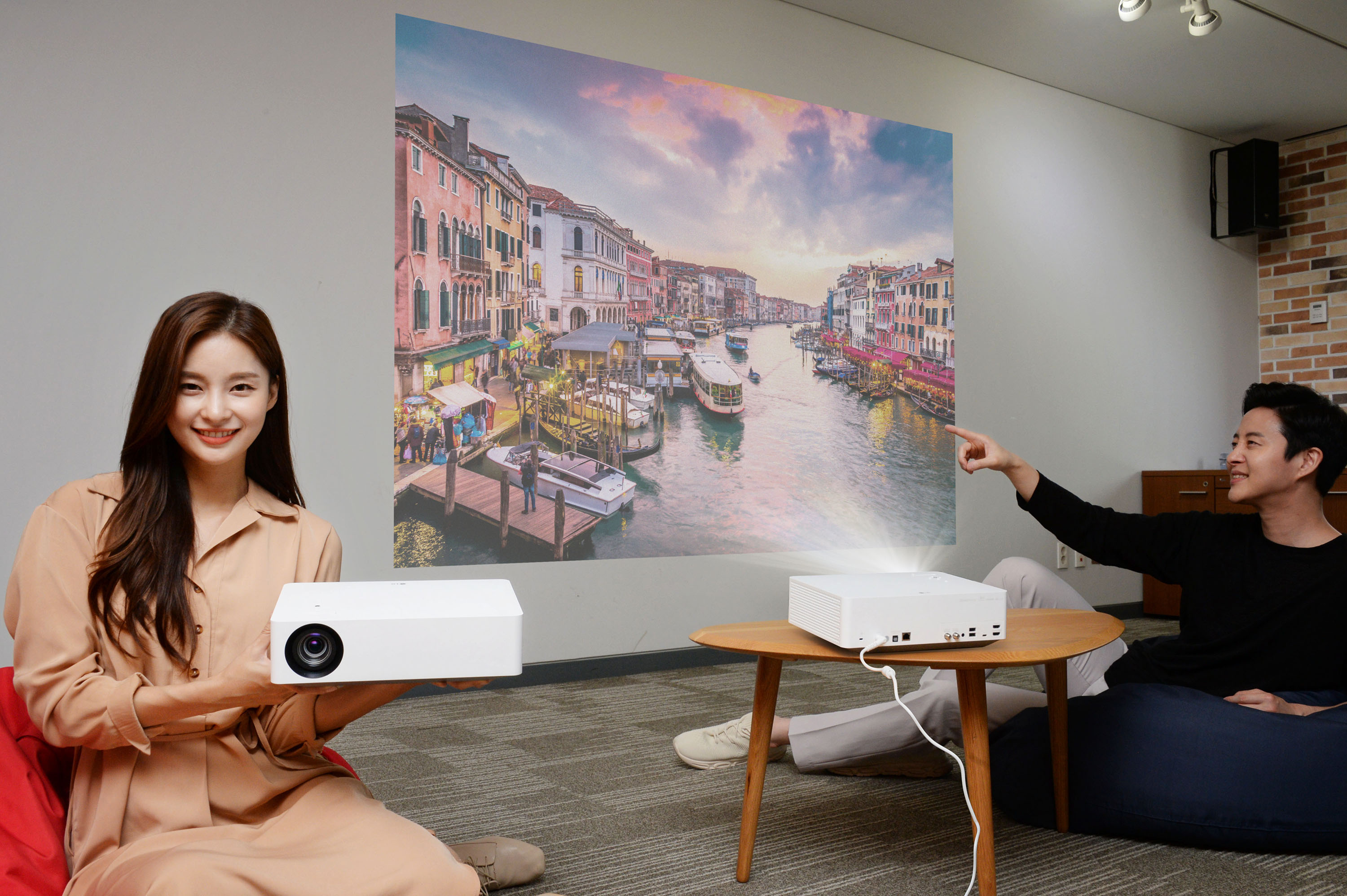 서울 여의도 LG트윈타워에서 모델들이 'LG 시네빔 4K' 프로젝터가 구현하는 초대형 화면으로 영상을 즐기고 있다.