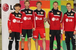 손흥민 선수를 비롯한 레버쿠젠 선수들이 그림 앞에서 기념촬영을 하고 있다.