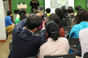 셀프카메라 기능을 체험해 보고 있는 어르신의 뒷 모습이다