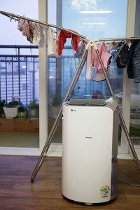 빨래 건조대 옆에 자리잡고 있는 휘센 제습기의 모습