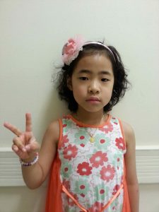 민주가 손가락 브이를 하며 서있다