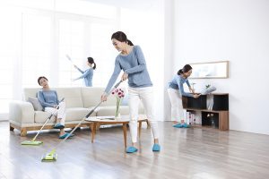 한 여성이 거실을 청소하고 있다.