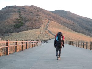 가방은 메고 산에 올라가는 모습