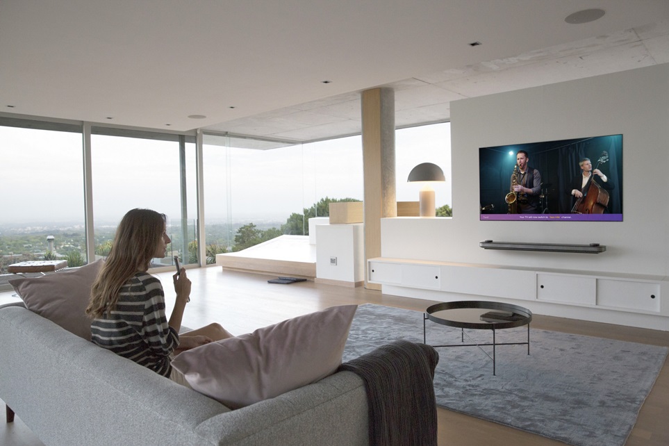고객이 LG 올레드 TV 의 음성인식 기능을 활용해 콘텐츠를 검색하고 있다.