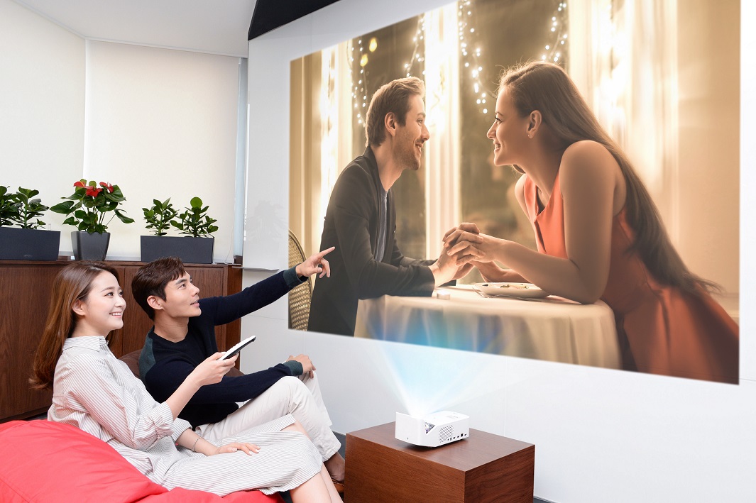 모델들이 2019년형 'LG 시네빔' 프로젝터를 이용해 초대형 화면으로 영화를 시청하고 있다.