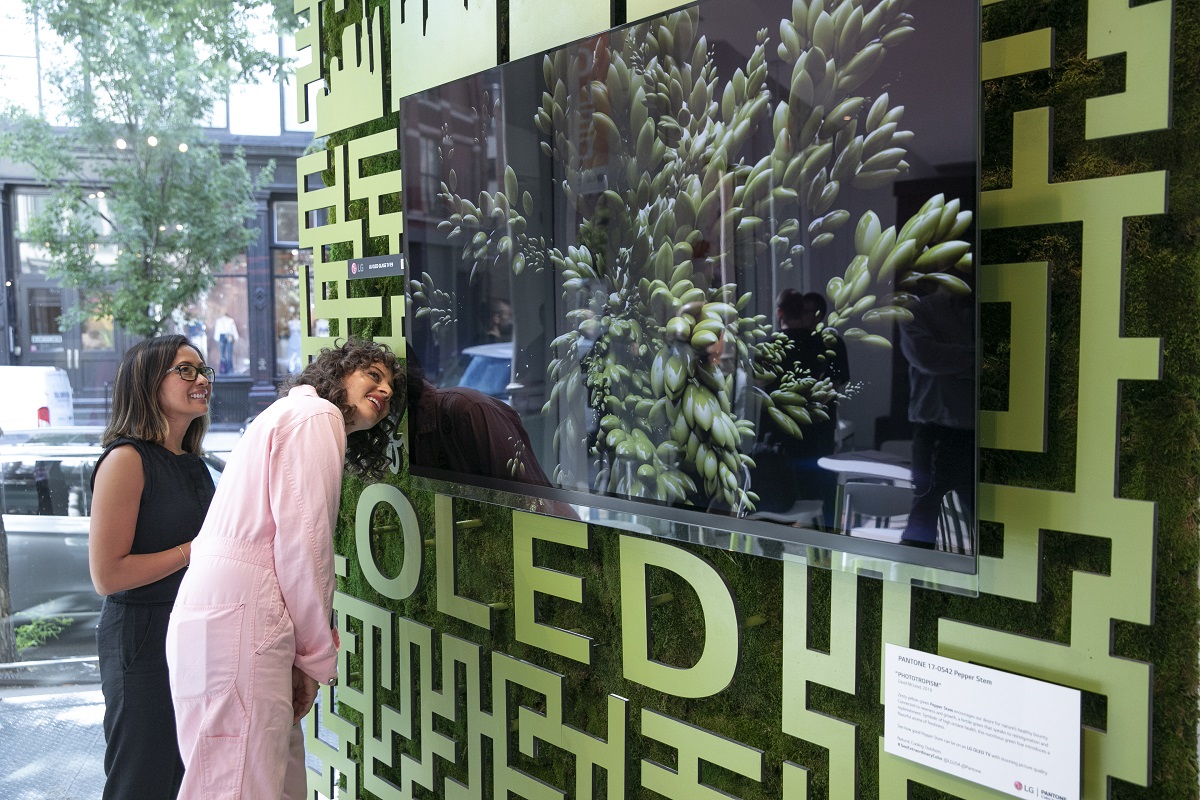 LG전자가 현지시간 12~14일 미국 뉴욕 맨해튼에서 운영한 '카페 올레드'에서 '아미라 카셈(오른쪽)' 셰프 등이 팬톤社가 선정한 올해의 여름 컬러 '페퍼 스템' 조형물 앞 LG 올레드 TV를 살펴보고 있다.