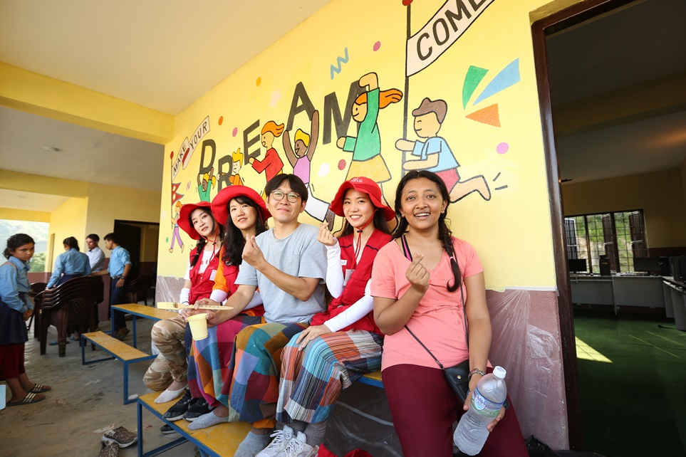 학교 외벽에 벽화를 그린 LG전자 임직원들